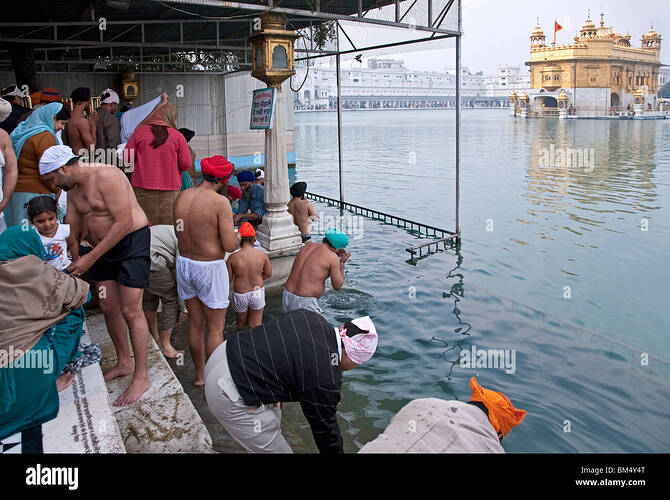 sikh-devotees-bathing-in-the-sacred-pool-the-golden-temple-amritsar-BM4Y4T